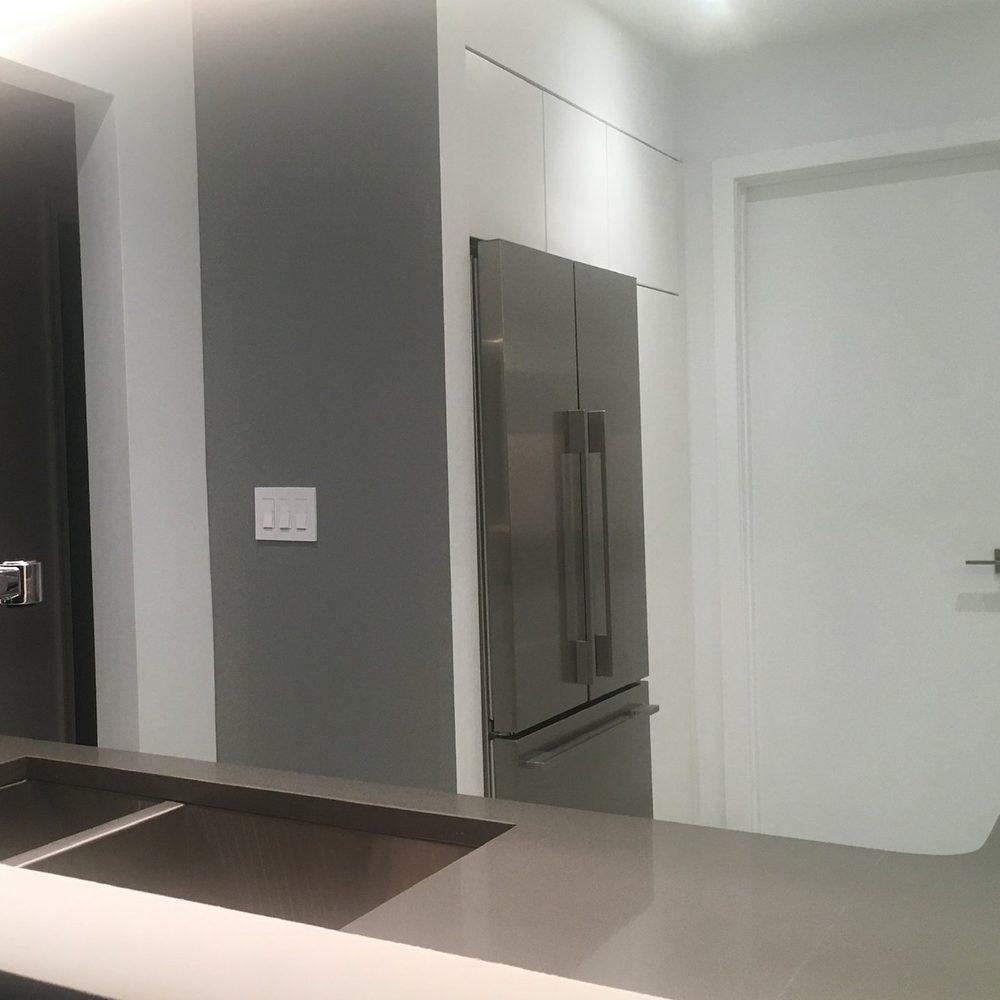 The refrigerator built in beside a pantry cabinet, with a full-height flush white door.