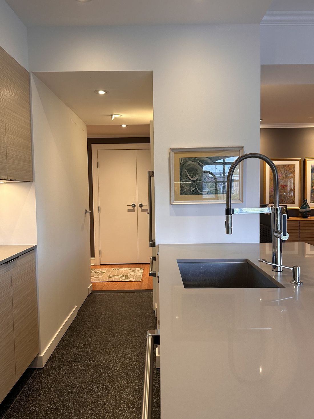 Looking down the corridor past the alcove and sink toward the closet doors, with the soffit line continuing overhead.